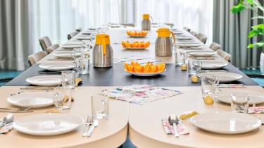 Een gedekte eettafel in een buurthuis voor een grote groep.