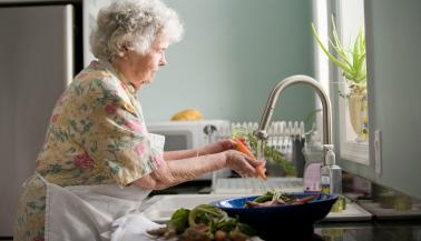 Oudere vrouw aan het koken
